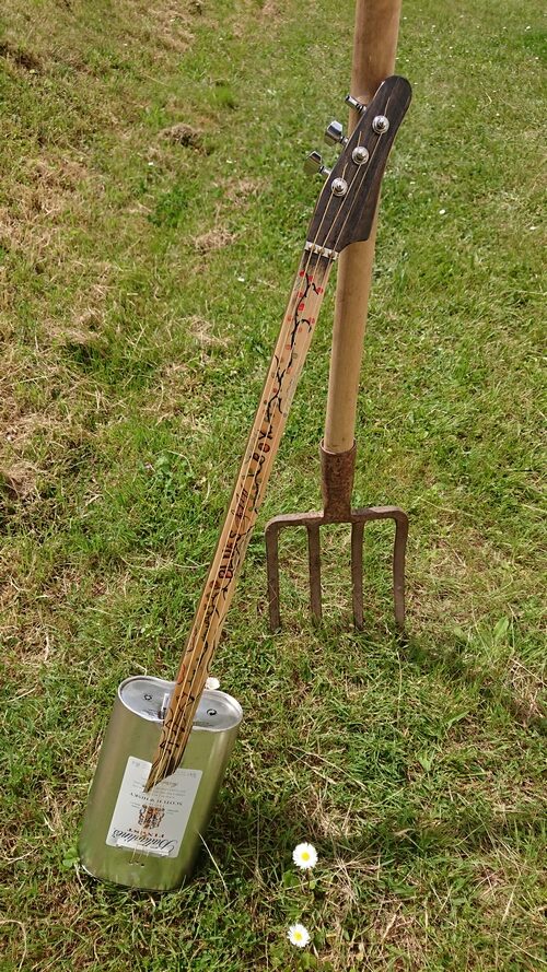 Cordophone fabriquée à partir d'une boîte métallique.